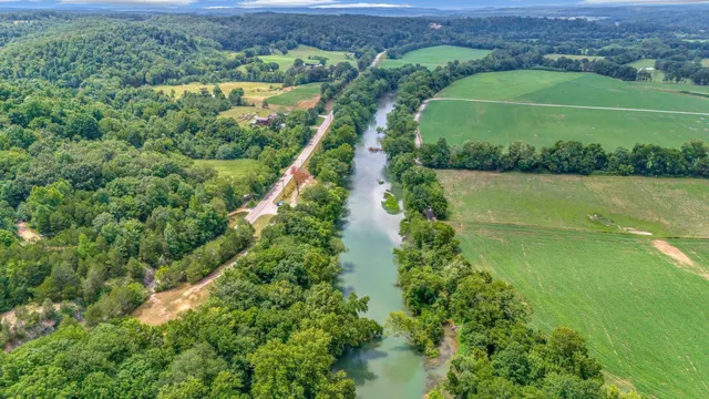 an aerial view of a houses with a lush green hillside