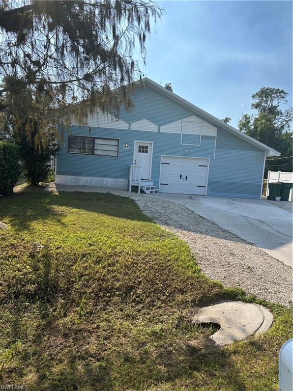 View of front facade with a garage and a front lawn