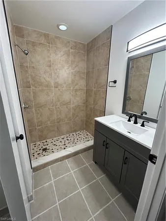 a bathroom with a shower sink and mirror
