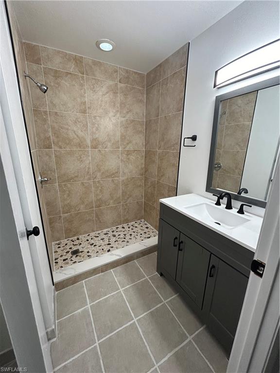 281 Benson Street Naples, FL 34113 - Photo 10 of 21 Bathroom featuring tiled shower, vanity, and tile patterned flooring