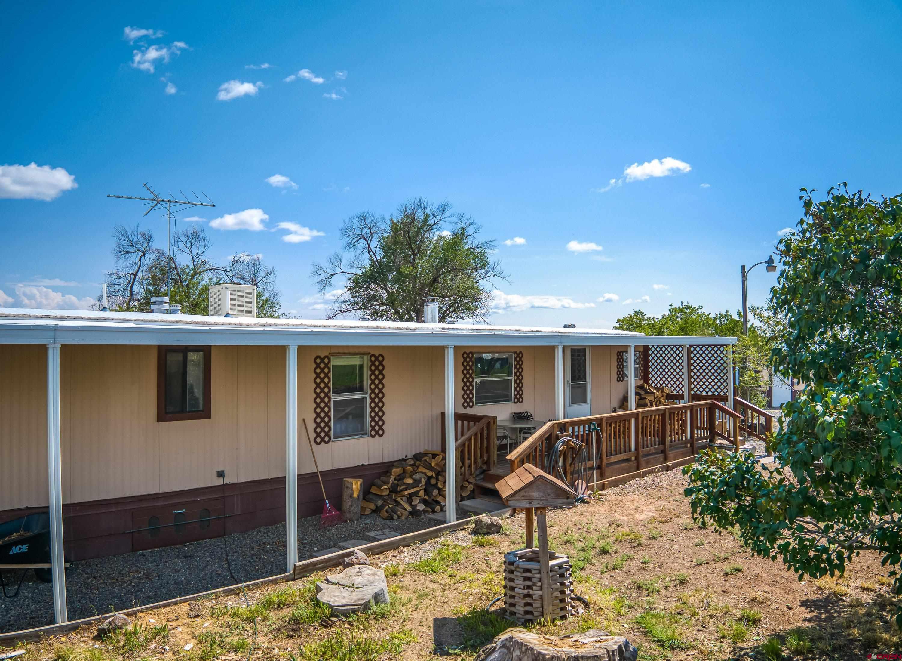 26069 Cedar Mesa Road Cedaredge, CO 81413 - Photo 12 of 29 a view of a house with backyard porch and furniture