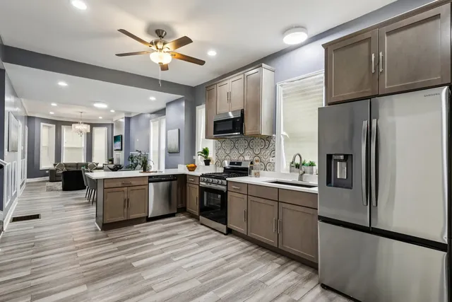 a large kitchen with cabinets a sink and stainless steel appliances