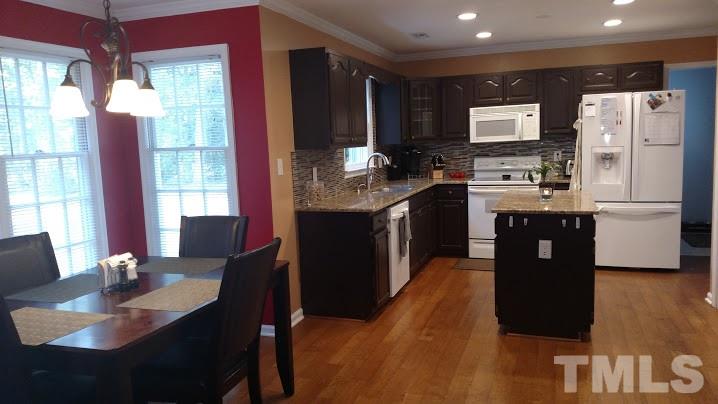 2216 Dobbin Place Raleigh, NC 27604 - Photo 8 of 25 a kitchen with stainless steel appliances granite countertop a refrigerator a stove a sink dishwasher with a dining table and chairs