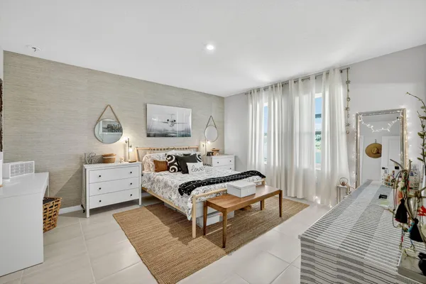 a spacious bedroom with a bed and a chandelier