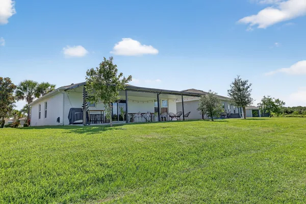 a view of a house with a backyard and trees
