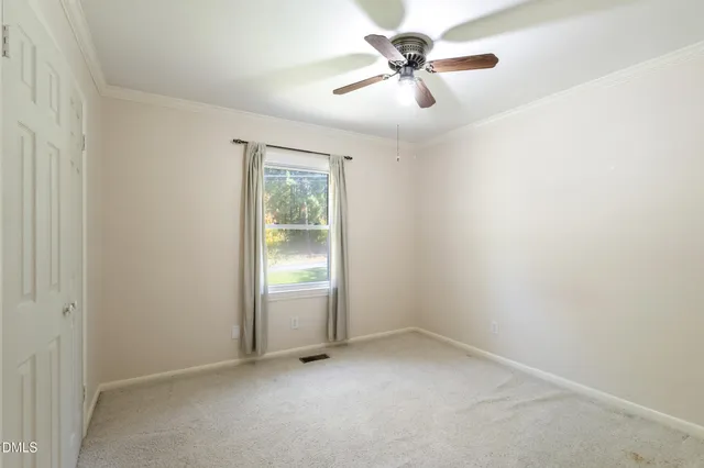 an empty room with a ceiling fan and a window