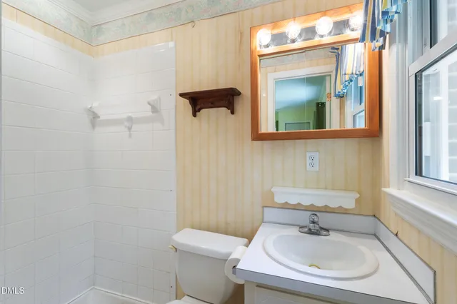 a bathroom with a sink a toilet and mirror