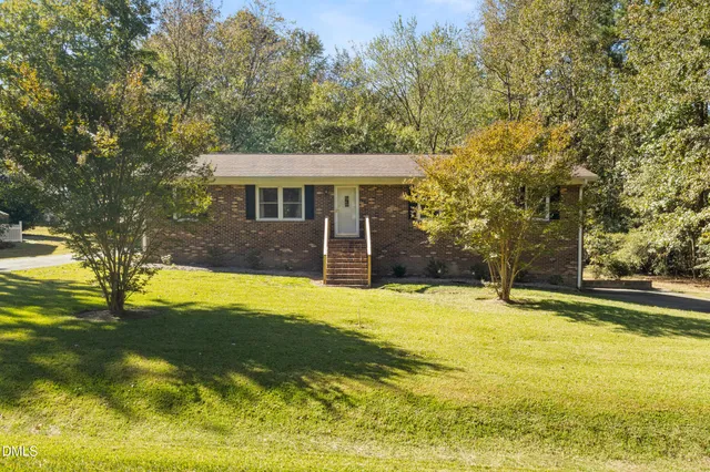 a view of a house with pool and a yard
