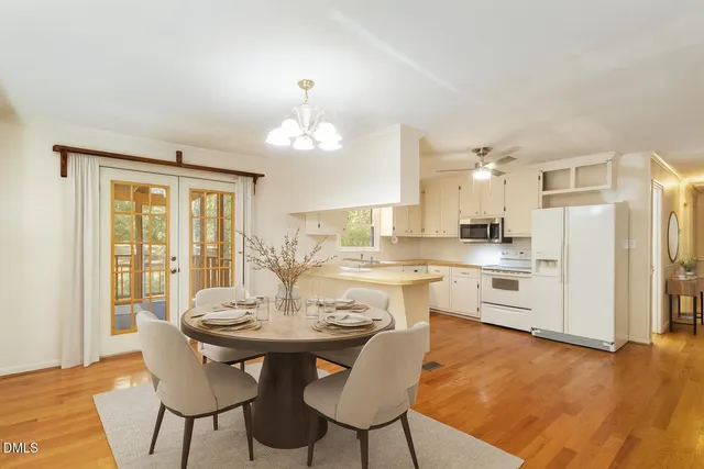 a kitchen with a dining table chairs and refrigerator