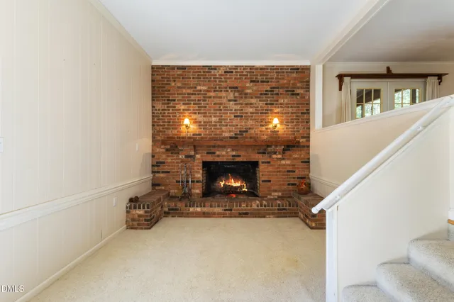 a view of an empty room with a fireplace and a window