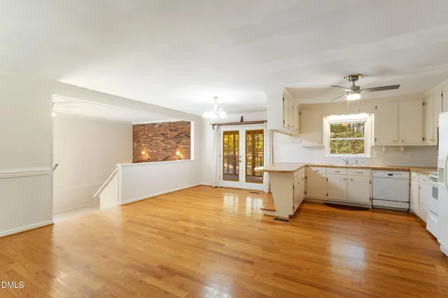a view of an empty room with window and wooden floor