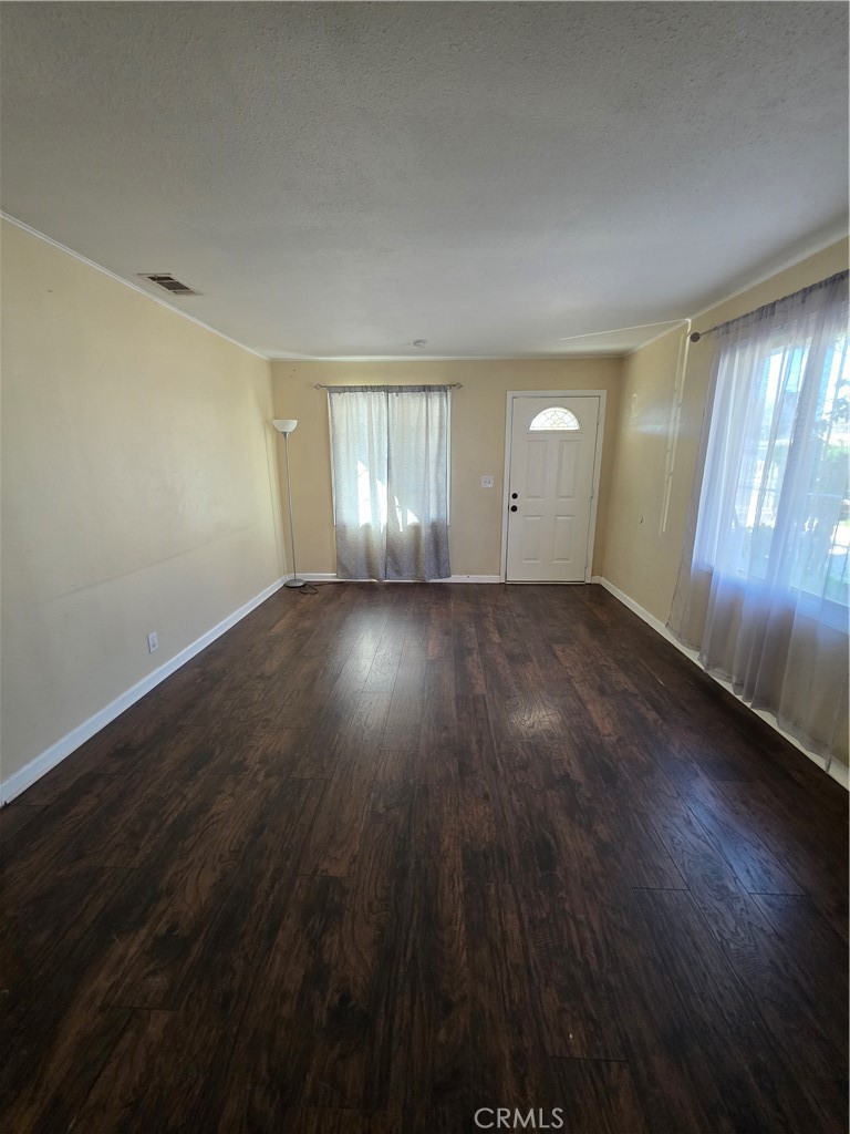338 South Gilbert Street Hemet, CA 92543 - Photo 5 of 14 an empty room with wooden floor and windows