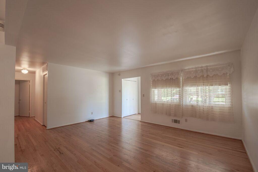 3824 Offutt Road Randallstown, MD 21133 - Photo 11 of 27 an empty room with wooden floor and windows