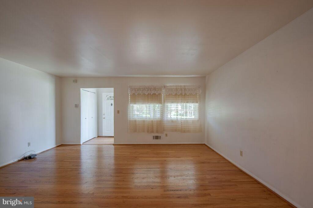 3824 Offutt Road Randallstown, MD 21133 - Photo 12 of 27 wooden floor in an empty room with a window