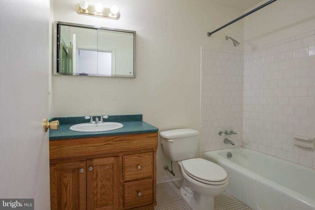 3824 Offutt Road Randallstown, MD 21133 - Photo 18 of 27 a bathroom with a granite countertop toilet a sink and a mirror
