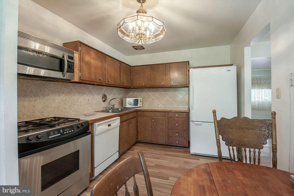 3824 Offutt Road Randallstown, MD 21133 - Photo 7 of 27 a kitchen with stainless steel appliances granite countertop a stove a sink and a refrigerator