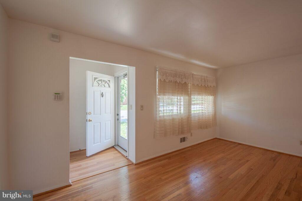 3824 Offutt Road Randallstown, MD 21133 - Photo 10 of 27 an empty room with wooden floor and windows