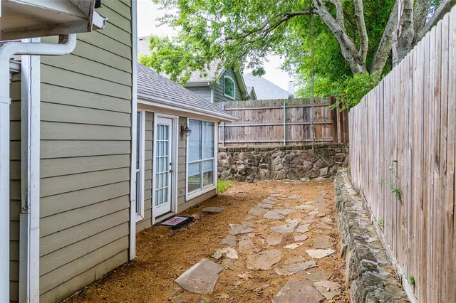 a view of a pathway of a house with wooden fence