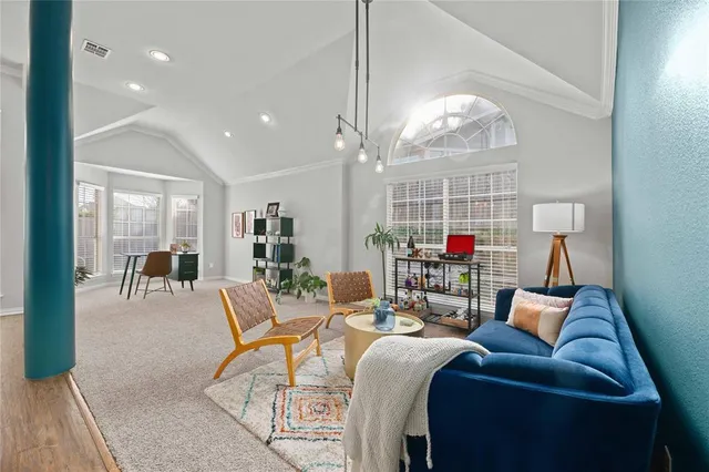 a living room with furniture a chandelier and a dining table