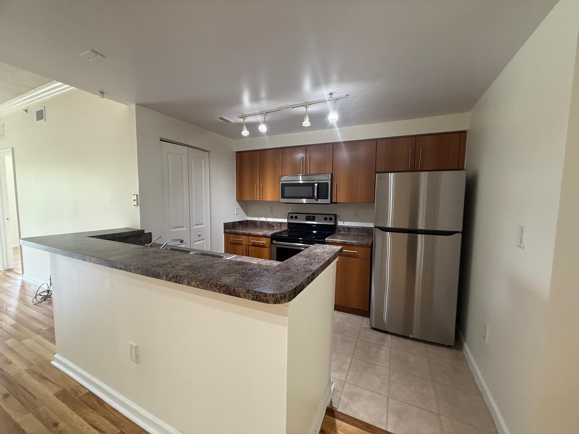 5800 West Sample Road, Unit 207 Coral Springs, FL 33067 - Photo 3 of 22 a kitchen with granite countertop a refrigerator and a sink