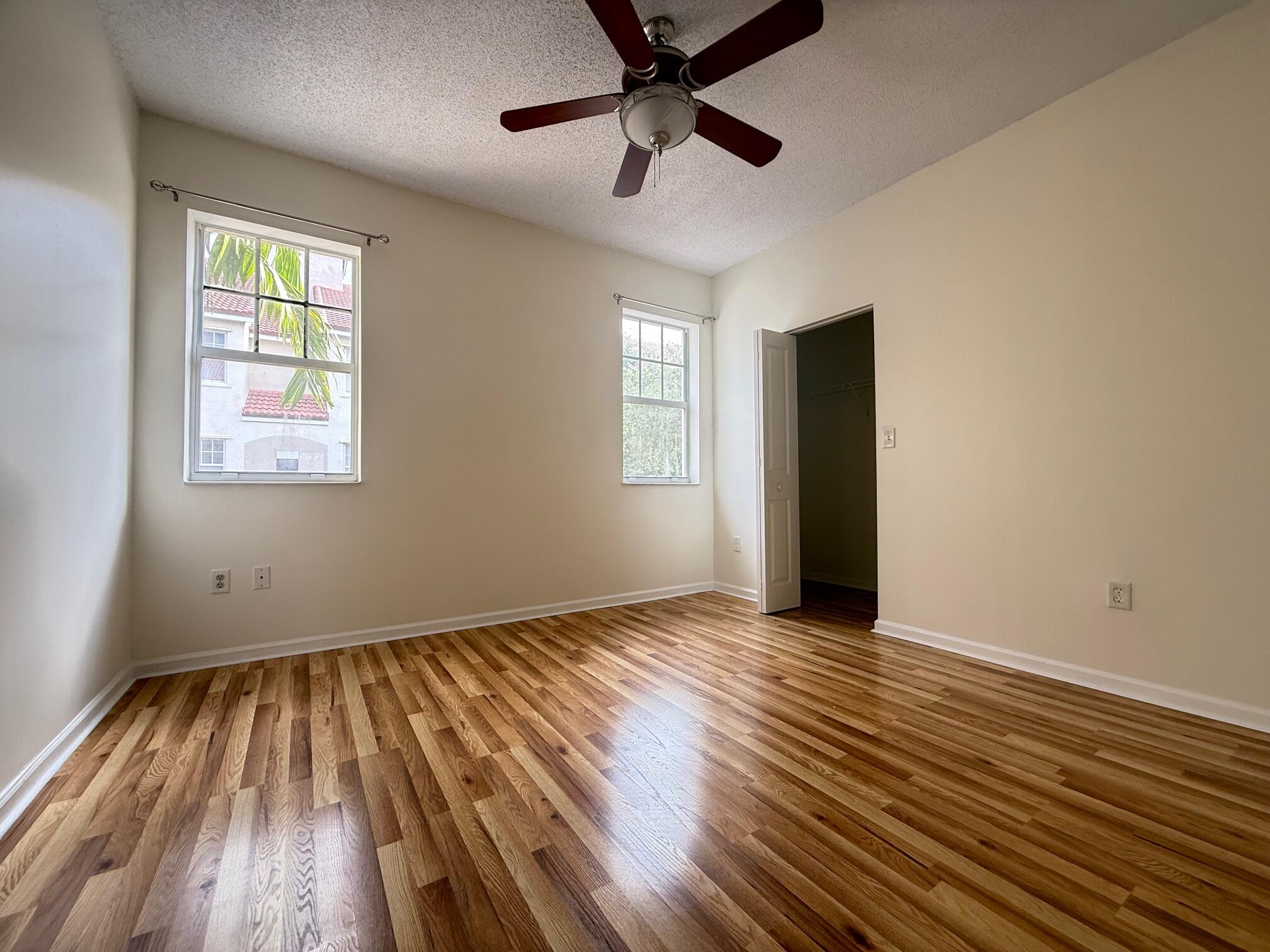 5800 West Sample Road, Unit 207 Coral Springs, FL 33067 - Photo 5 of 22 a view of an empty room with wooden floor and a window