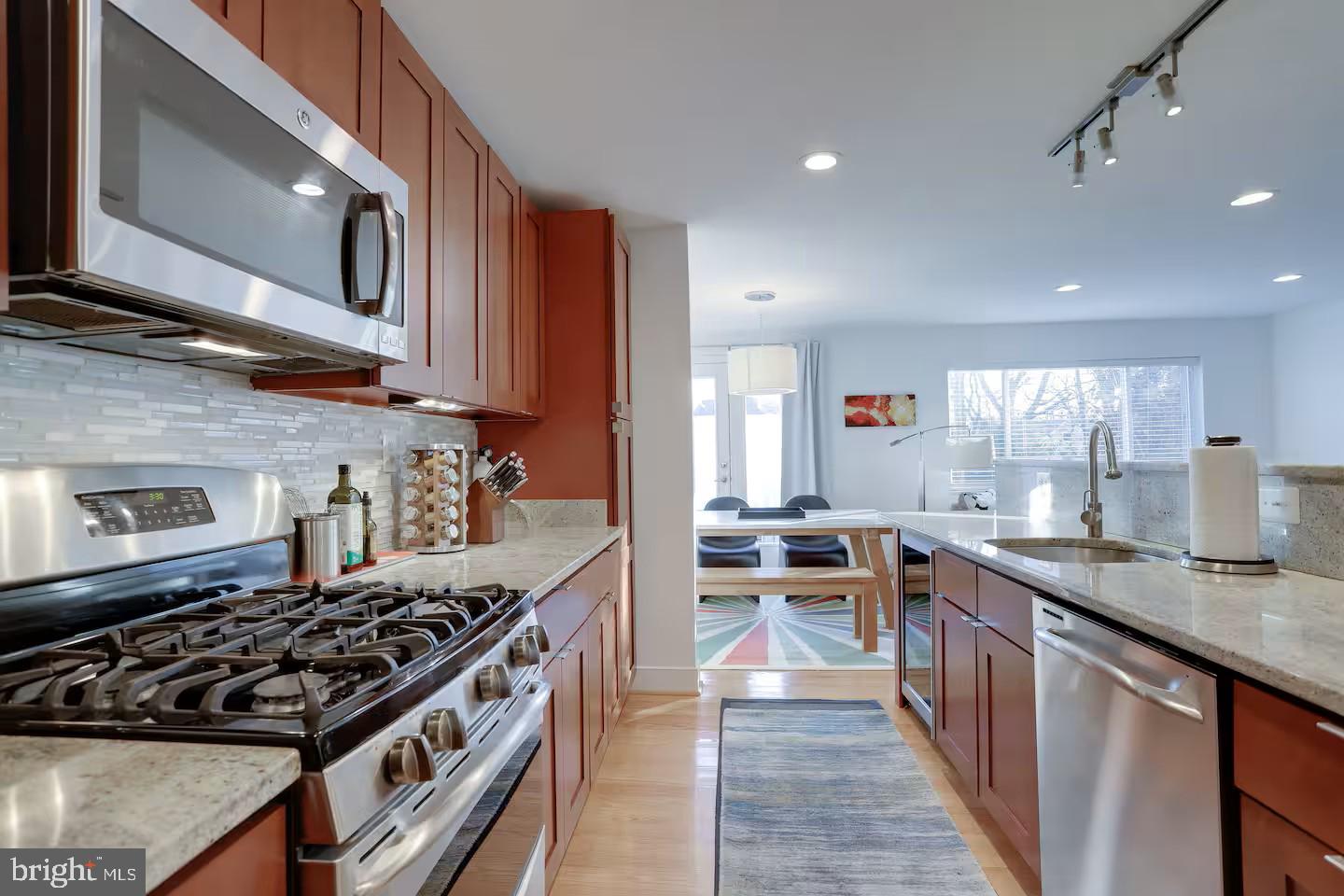 4118 18th Road North Arlington, VA 22207 - Photo 28 of 48 a kitchen with stainless steel appliances granite countertop a stove a sink dishwasher and a microwave oven with large wooden cabinets