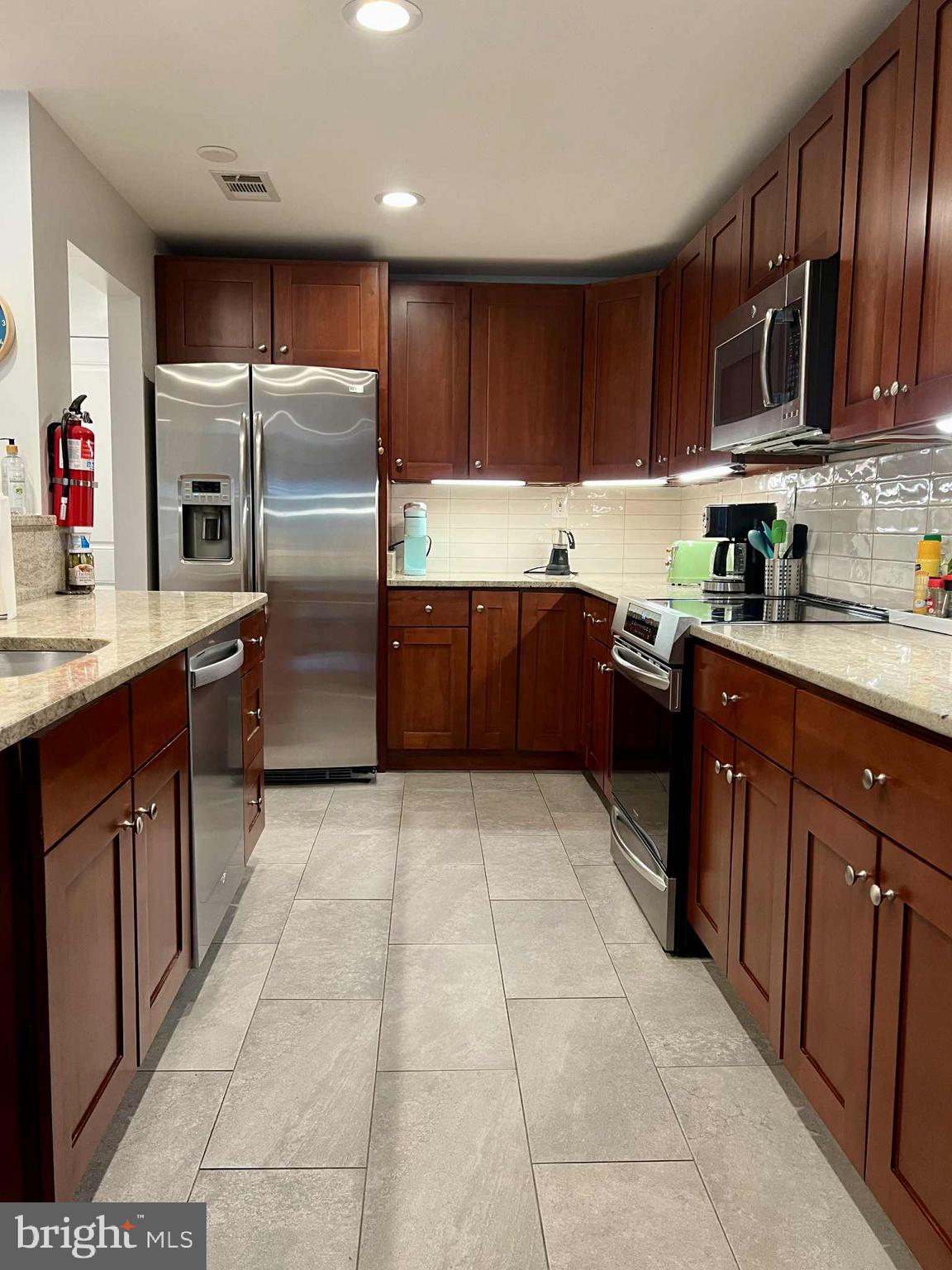 4118 18th Road North Arlington, VA 22207 - Photo 7 of 48 a kitchen with stainless steel appliances granite countertop a stove refrigerator and cabinets