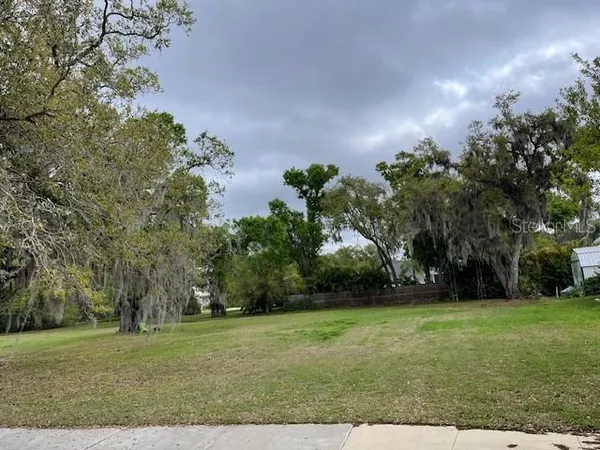 a view of a field with trees in the background