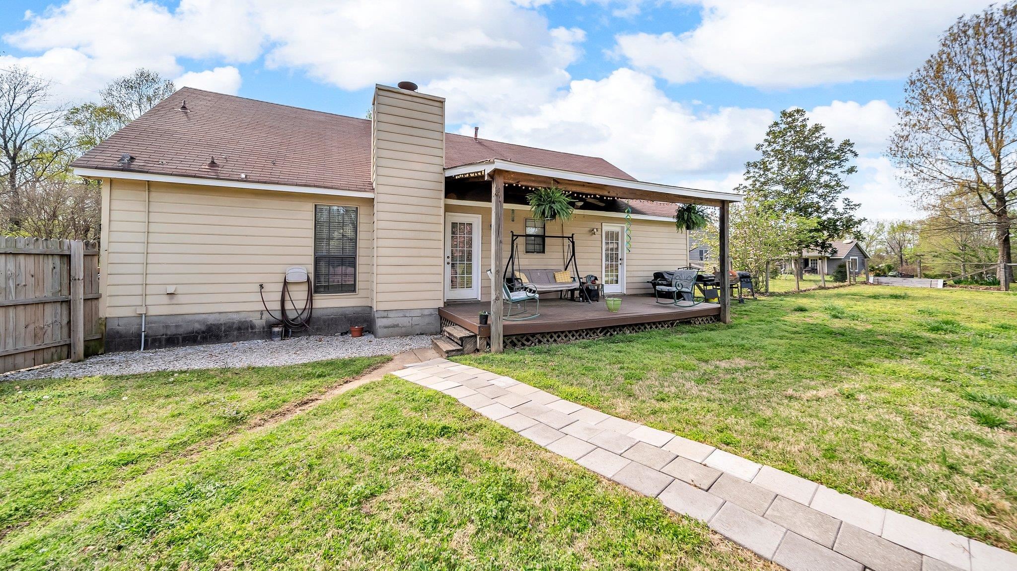 6488 Chase Road Millington, TN 38053 - Photo 6 of 22 Rear view of house with a chimney, a deck, fence, and a lawn