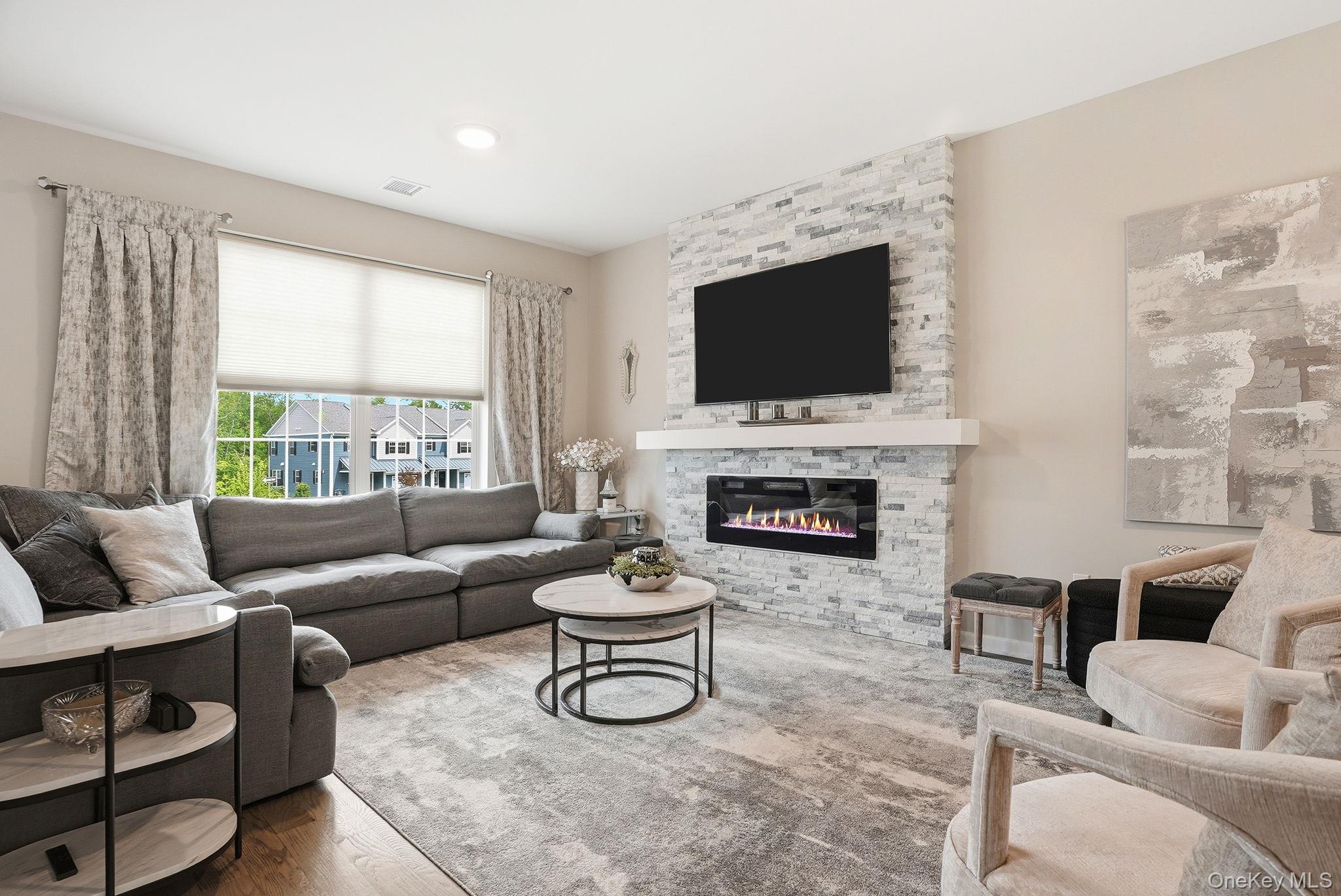 8 Muscoot River Road Granite Springs, NY 10527 - Photo 6 of 40 Living area featuring a stone accent wall with an inset electric fireplace and wood-finish flooring
