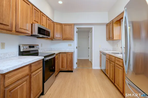 a kitchen with stainless steel appliances granite countertop a stove a sink and a refrigerator