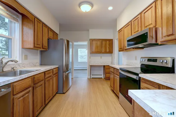 a kitchen with stainless steel appliances granite countertop a sink stove microwave and refrigerator