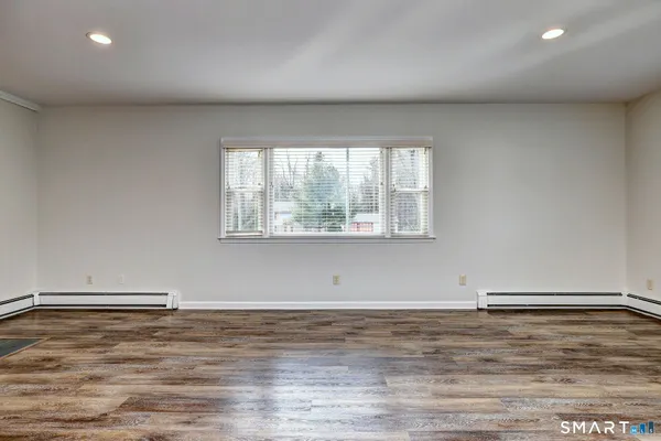 a view of a room with wooden floor and window