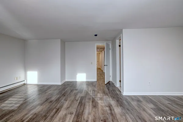 a view of empty room with wooden floor