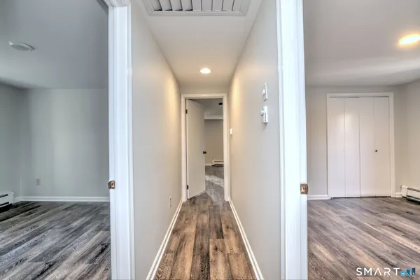 a view of a hallway with wooden floor and staircase