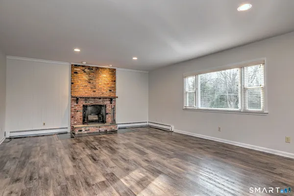 a view of an empty room with a fireplace and a window