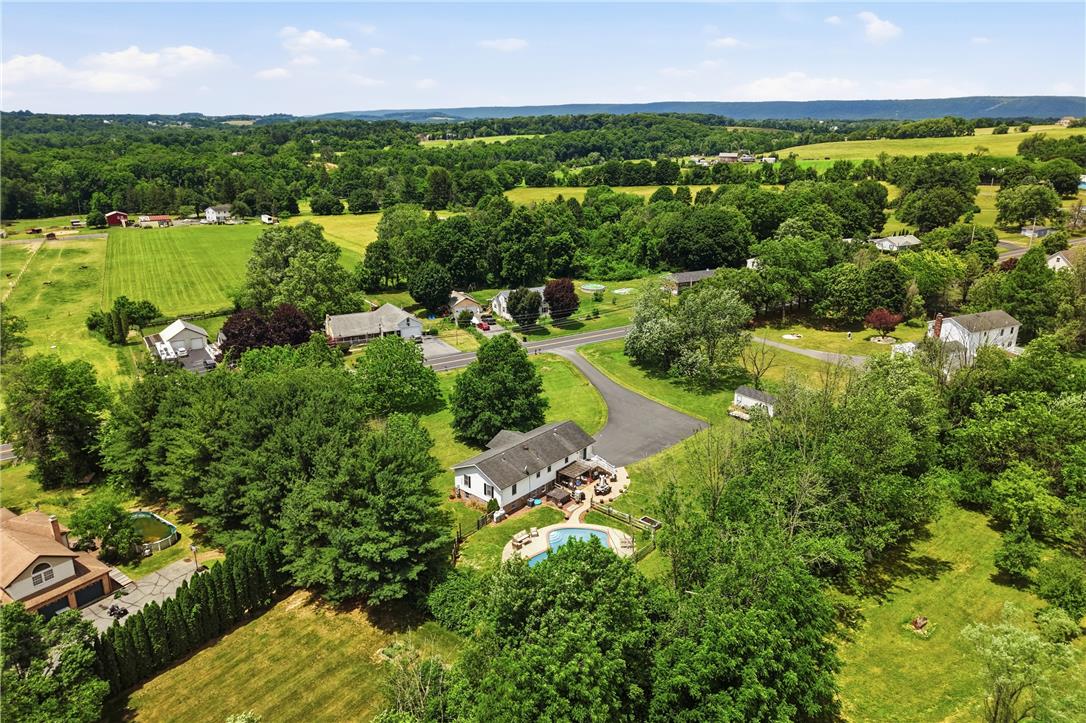 732 Bushkill Center Road Nazareth, PA 18064 - Photo 40 of 43 An aerial panorama reveals a private pool with ample surrounding patio space, nestled among a verdant landscape.
