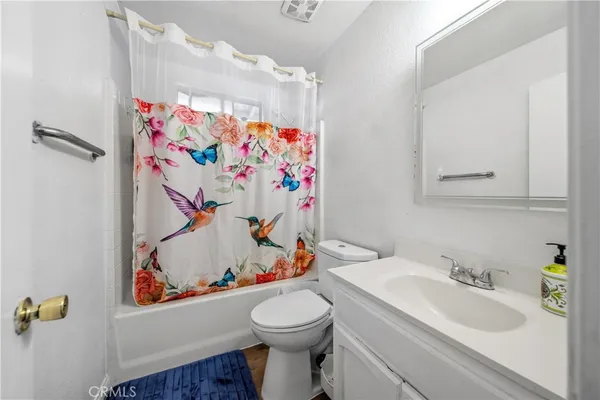 a bathroom with a sink toilet and a shower curtain