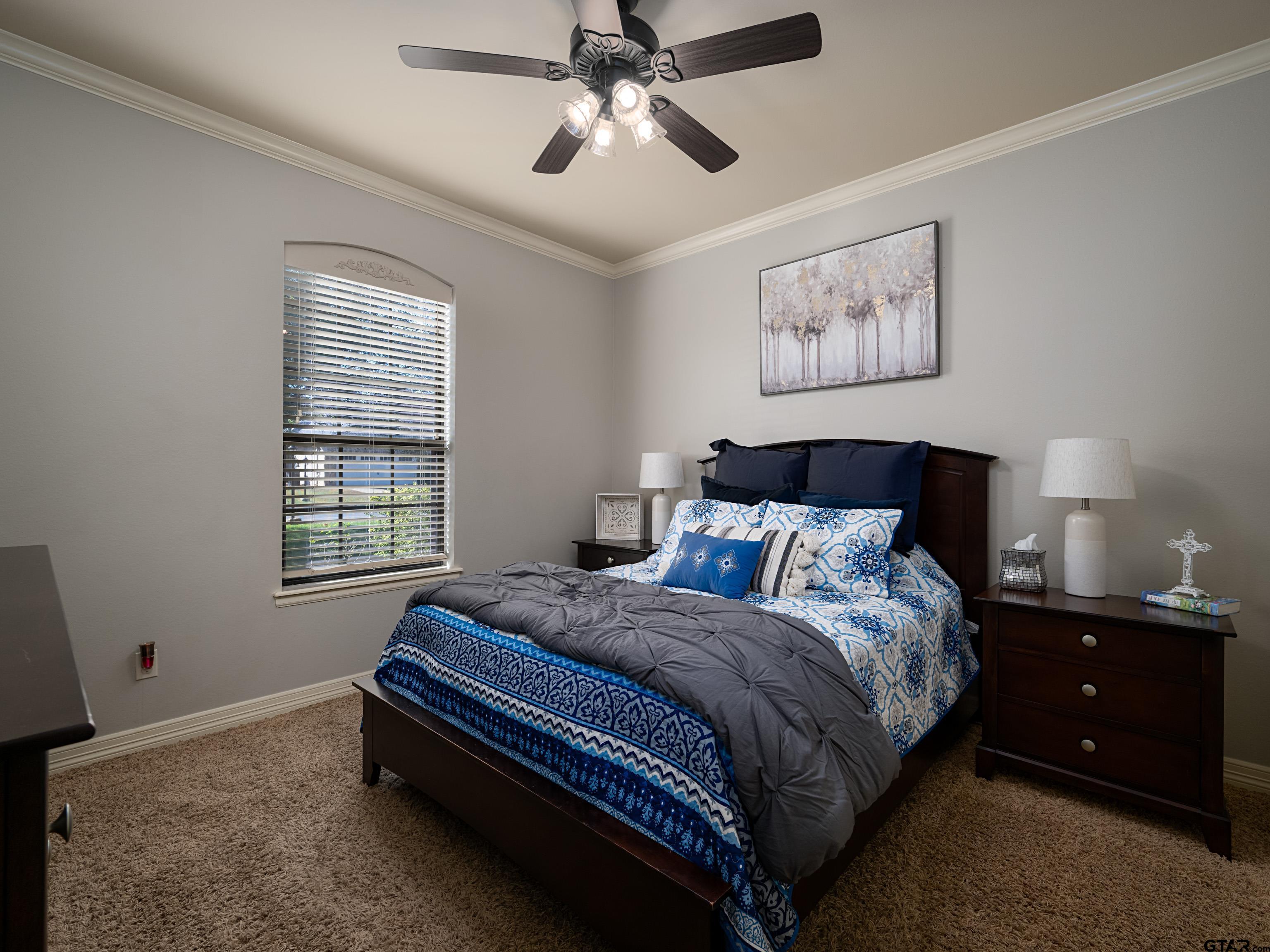 19560 Sandhill Lane Flint, TX 75762 - Photo 29 of 35 a spacious bedroom with a bed and a chandelier