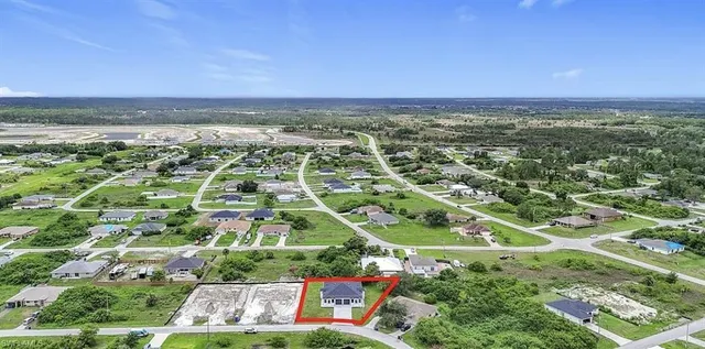 an aerial view of residential houses with outdoor space and trees