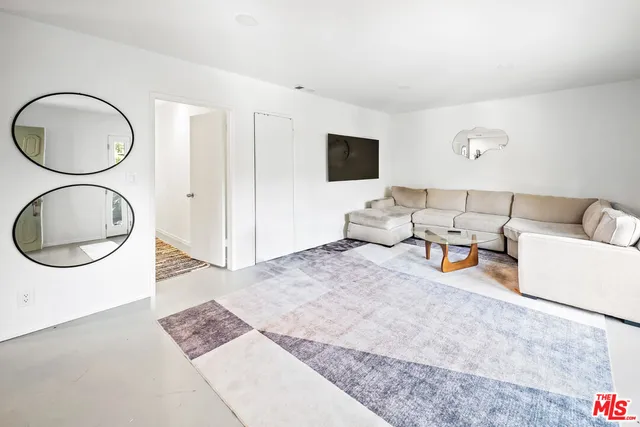 a living room with furniture a mirror and a lamp