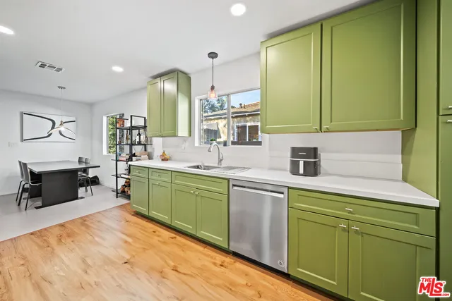 a kitchen with a sink cabinets and wooden floors