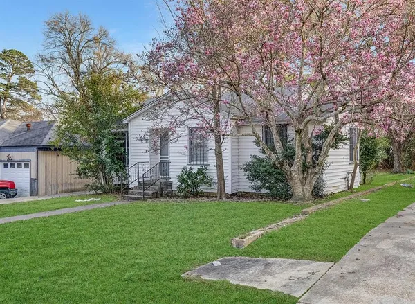 a front view of a house with a yard and trees