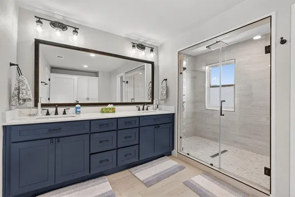 a bathroom with a double vanity sink and a mirror