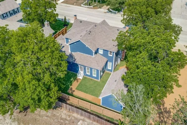 an aerial view of residential houses with outdoor space and trees