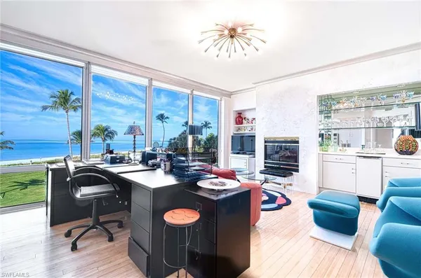 a view of a dining room with furniture a chandelier and wooden floor