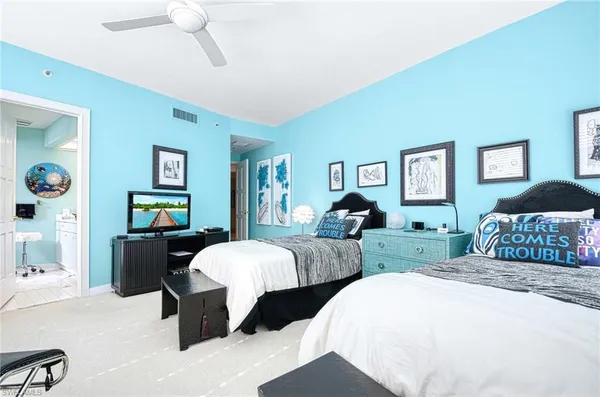 a bedroom with two beds and a large mirror