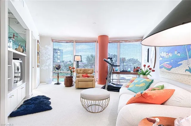 a living room with furniture and a floor to ceiling window
