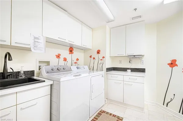 a kitchen with a sink dishwasher and white cabinets