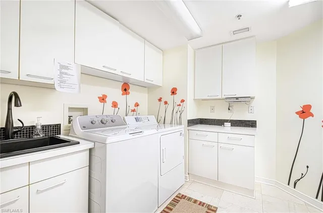 a kitchen with a sink dishwasher and white cabinets